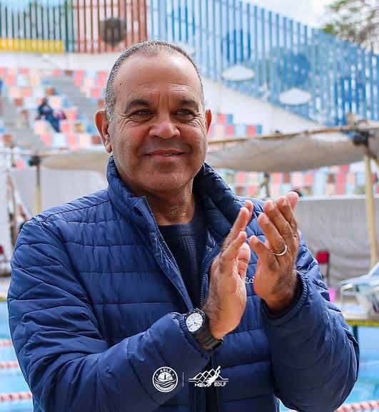 Captain Sameh El Shazly applauding beside an Olympic swimming pool