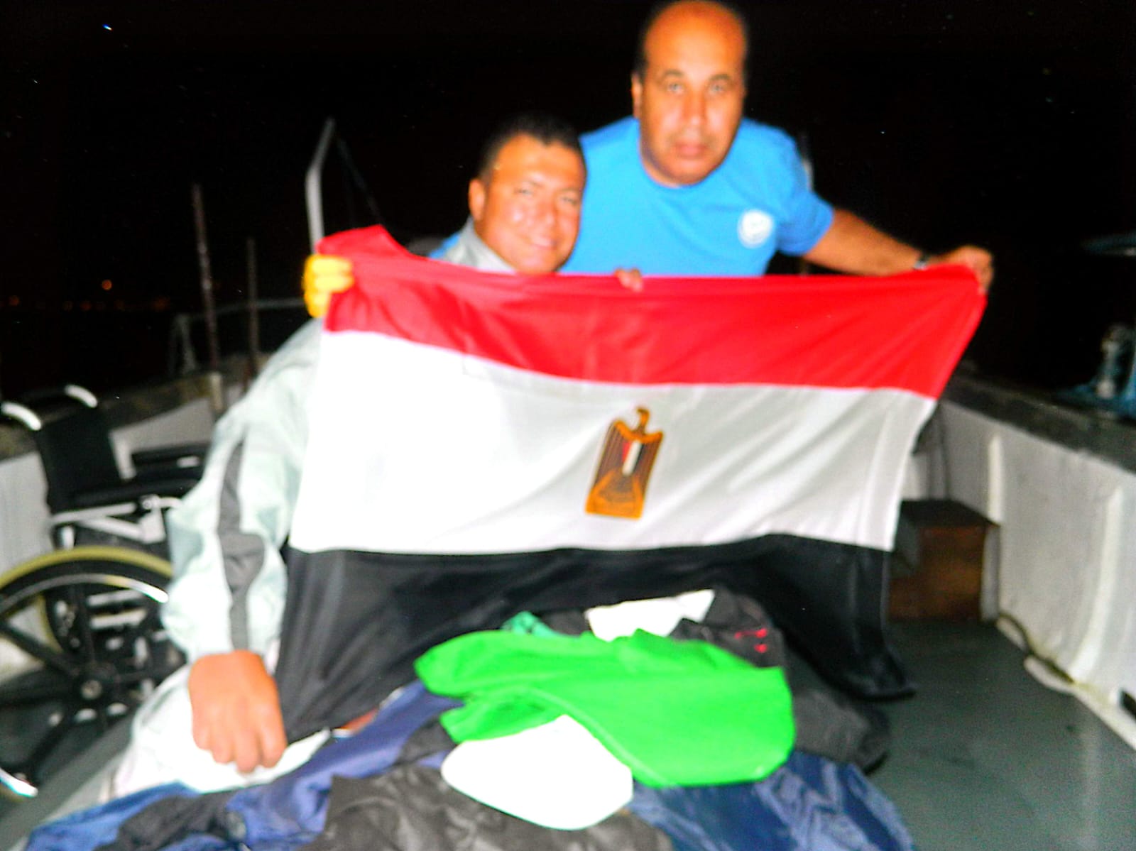 Ahmed Nasef with a member of the support crew on the boat at night.